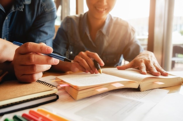 education-concept-student-studying-brainstorming-campus-concept-close-up-students-discussing-their-subject-books-textbooks-selective-focus_1418-627